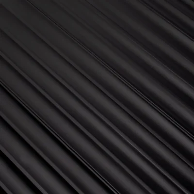 Közeli felvétel a matt fekete bordázott Inspira Lux falpanel felületéről